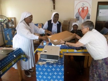 Sr. Selina Chimzukira receiving a Computer from Sr. Gail and Sr. H. Chombo